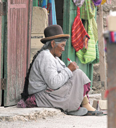 Una chola, con su típico sombrero, descansa sobre las calles del pueblo de Uyuni